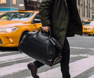 a person walking down a street next to a car