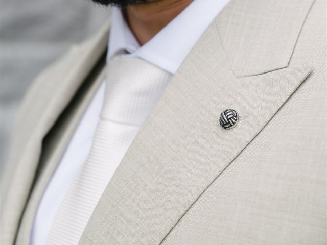 a man wearing a suit and tie smiling at the camera