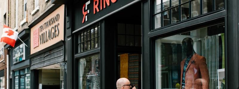 a man walking down a sidewalk in front of a store