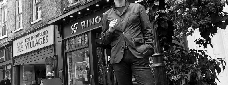 a person standing on a sidewalk in front of a building