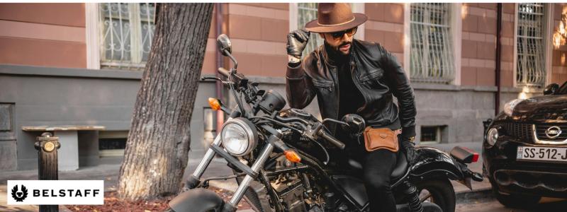 a person sitting on a motorcycle in front of a building